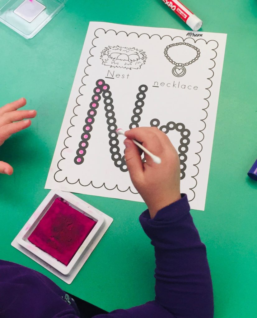 Stamping the letter N at then literacy center